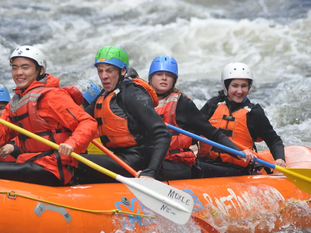 I this image, I can see a group of people holding paddles and sitting on an inflatable boat, which...