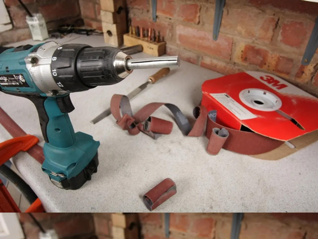 This is a collage image, in this image we can see a hole drilling machine and a few other tools on...