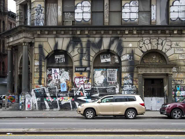 In this image we can see buildings with graffiti on them, grills, staircases, railings, sky and...