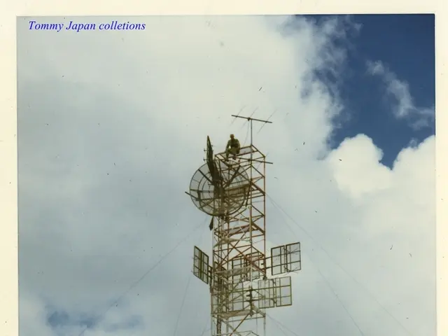 There is a vehicle, shelters and a tower present at the bottom of this image, and there is a cloudy...