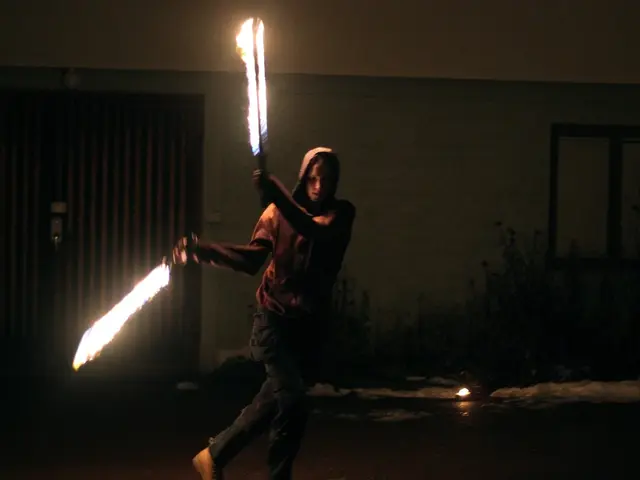 In the foreground, I can see a person is holding fire sticks in hand. In the background, I can see...