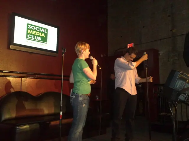 As we can see in the image there is a wall, tray, bench and two people holding mics.