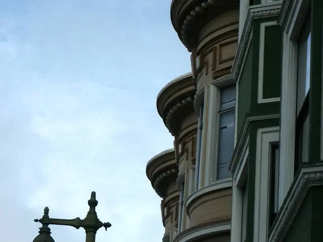 In this picture I can see a building and and a pole lights with couple of advertisement boards and...