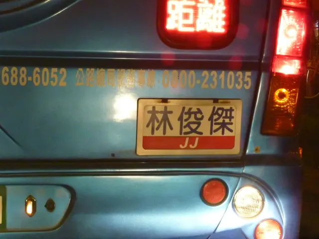 In this picture we can see a close view of the blue car trunk and tail lights. On the right corner...