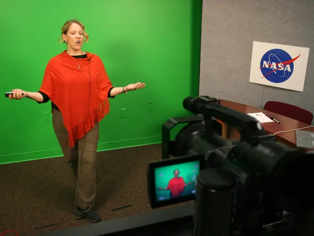 In this image there is a woman standing and wearing a red scarf is having a watch to her hand. At...