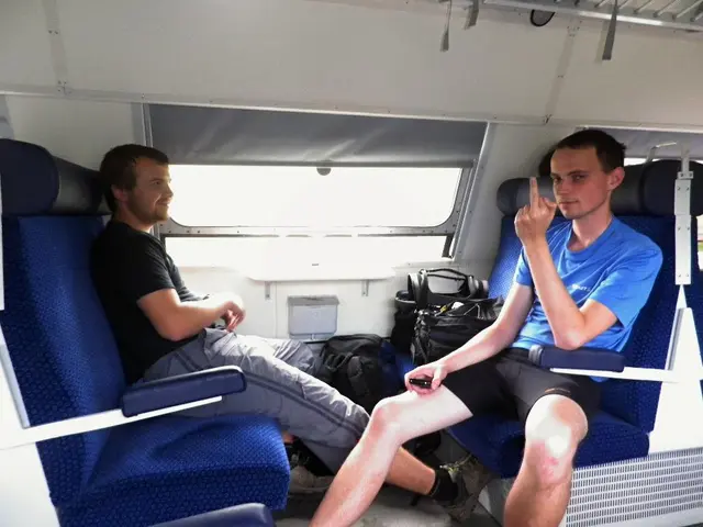 In this image in the center there are persons sitting and smiling and there are bags in the front....