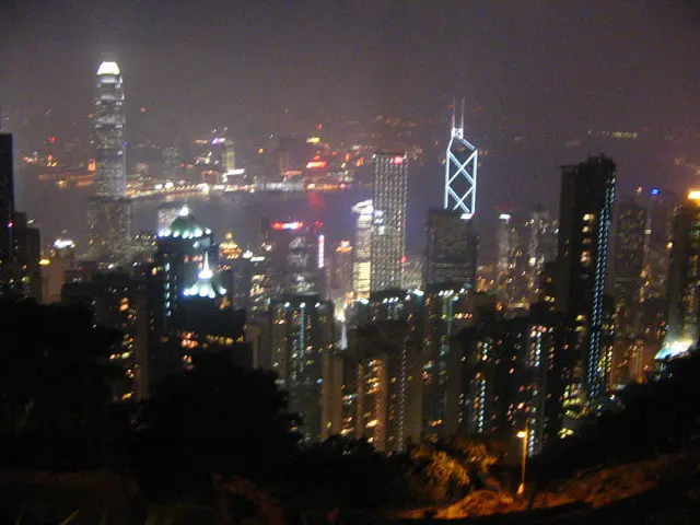 In this picture we can see buildings, trees, lights, water and some objects and in the background...